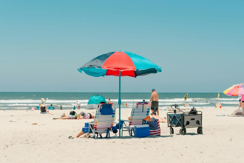 Sunny beach day with colorful umbrella and beach chairs