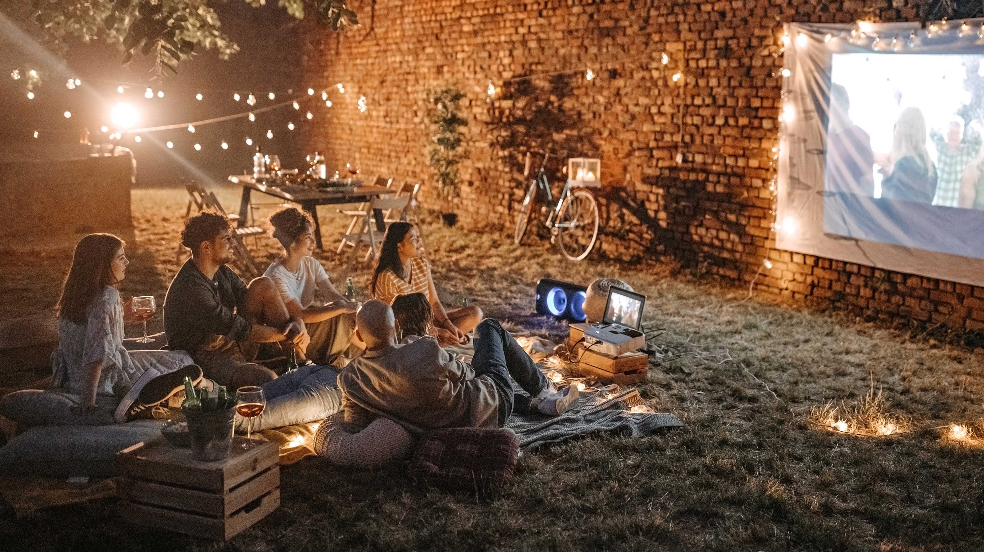 Cozy outdoor movie night with friends and string lights